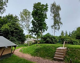 Verken de serene natuur en het terras bij Vakantiehuisje in Muntendam, Zuidoost Groningen voor een ontspannen verblijf.