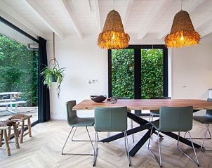 Eetkamer met houten tafel in Huisje in Haren, vakantieverblijf in Zuidwest Groningen, omgeven door groen.