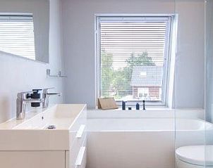 Ruime badkamer met bad in Huisje in Haren, vakantiehuis in Groningen, voorzien van natuurlijk licht.