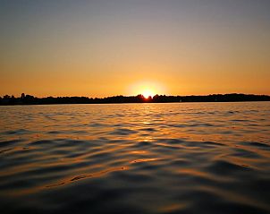 Adembenemende zonsondergang boven het meer bij Vakantiehuisje in Haren, een serene locatie in Zuidwest Groningen.