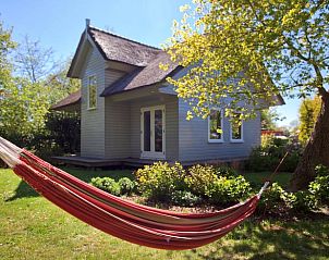 Rode hangmat in de tuin van Vakantiehuisje in Haren, een perfecte plek voor ontspanning in Zuidwest Groningen.