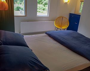 Lichte slaapkamer met grote ramen in Huisje in Haren, Groningen