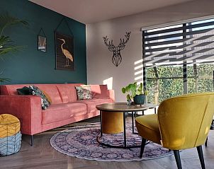 Stijlvolle woonkamer in Vakantiehuisje in Haren met kleurrijke meubels en moderne decoratie.