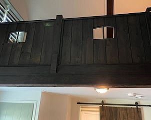 Houten trap en loft in Vakantiehuisje in Noordwijk, biedt een gezellige sfeer in Zuidwest Groningen.