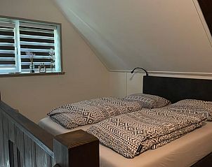 Comfortabele slaapkamer op de loft van Vakantiehuisje in Noordwijk, ideaal voor een goede nachtrust.