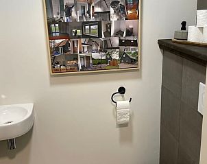 Toilet met collage aan de muur in Vakantiehuisje in Noordwijk, Groningen.