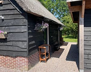 Zijaanzicht van Vakantiehuisje in Noordwijk met bloemen, Zuidwest Groningen.