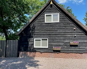 Vooraanzicht van Vakantiehuisje in Noordwijk met bloembakken, Zuidwest Groningen.