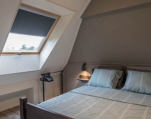 Zolderslaapkamer met dakraam in Huisje in Opende, vakantiehuis in Groningen.