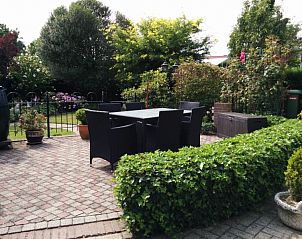 Gezellig terras bij vakantiehuis Linssen in Stevensweert, Limburg omringd door groen.