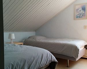 Tweepersoonskamer onder het schuine dak in vakantiehuis Linssen in Stevensweert, Limburg.