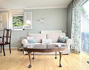 Gezellige woonkamer van Rose Garden vakantiehuis in Stevensweert, Limburg met comfortabele bank en decoratieve kussens.