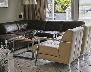 Gezellige woonkamer van Maaszicht vakantiehuis in Stevensweert, Limburg met comfortabele zitplaats en uitzicht op de natuur.