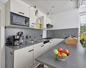 Moderne keuken in Aan de Oever vakantiehuis, Stevensweert met apparatuur en uitzicht op natuur.