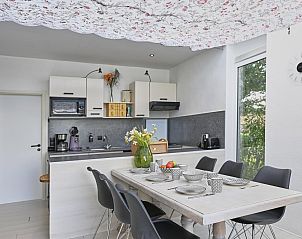 Eetruimte in Aan de Oever vakantiehuis, Stevensweert met stijlvolle inrichting en grote tafel.