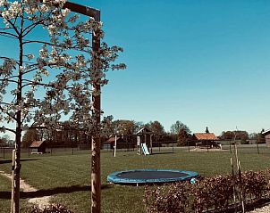 Ruime tuin met speeltoestellen bij Vakantiehuis in Leveroy, Midden Limburg.