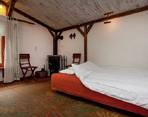 Gezellige slaapkamer in Huisje in Leudal, vakantiehuis in Midden Limburg, met rustieke houten balken en een knusse houtkachel.