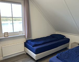 Slaapkamer met uitzicht op het meer in Chalet in Susteren, Midden Limburg, voor een serene sfeer.