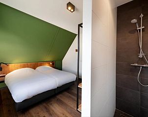 Sfeervolle slaapkamer in Premium Outdoor 8 vakantiehuis, Thorn, Limburg, met houten vloer en moderne inrichting.