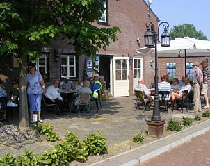Cozy terrace with umbrellas at Apartment Green, Blue or Red in Horst, North Limburg, perfect for relaxation.