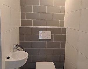 Modern toilet in Vakantiehuis Cube Magnifique 10 in Belfeld, Noord Limburg met strakke tegelafwerking.