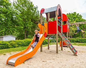 Kleurrijke speeltuin bij Vakantiehuis Cube Magnifique 10 in Belfeld, Noord Limburg met glijbaan en zand.