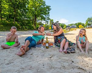 Gezin geniet van een picknick op het strand bij Vakantiehuis L-Cube Sauna 4 in Belfeld, Noord Limburg.