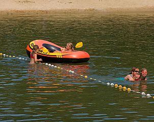 Kinderen zwemmen en varen in het meer bij Vakantiehuis L-Cube Sauna 4 in Belfeld, Noord Limburg.