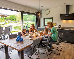 Familie geniet van maaltijd in Vakantiehuis Cube Elite 6, Belfeld, Noord Limburg, met uitzicht op natuur.