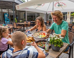 Gezin dineert op terras van Vakantiehuis Cube Elite 6, Belfeld, Noord Limburg, met heerlijke gerechten.
