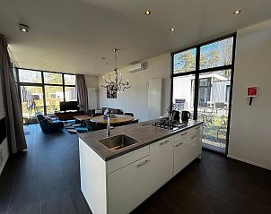 Lichte woonkamer van Chalet in Belfeld, Noord Limburg met uitzicht op terras en tuin.