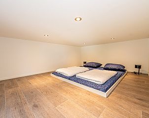 Grote slaapkamer met houten vloer in vakantiewoning in Belfeld, Noord Limburg, Limburg.