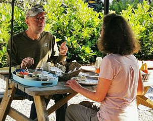 Twee gasten genieten van een maaltijd buiten bij Vakantiehuis in America, Limburg.