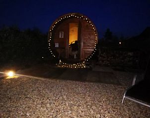 Verlichte sauna in de avond in Vakantiehuisje in America, Noord Limburg, voor ontspanning onder de sterren.