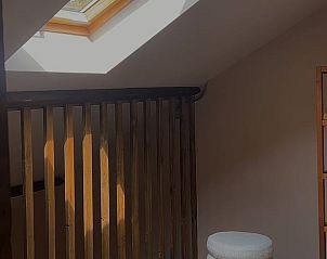 Lichte zolderruimte in Vakantiehuisje in America, Noord Limburg, met dakraam en houten elementen.