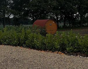 Ontspannende hot tub in de tuin van Vakantiehuisje in America, Noord Limburg, omgeven door natuur.