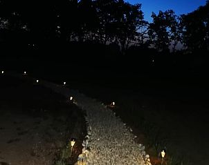 Verlichte tuinpad bij nacht in Vakantiehuisje in America, Noord Limburg, voor een magische sfeer.