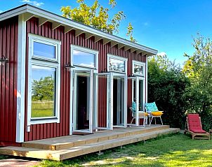 Buitenkant van Vakantiehuis in Heijen, Noord Limburg met terras en ligstoelen omgeven door groene natuur.