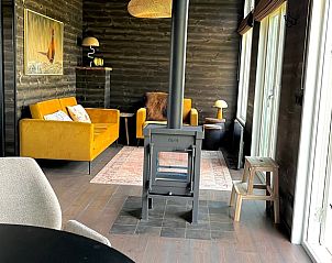 Knusse zithoek in Vakantiehuis in Heijen, Noord Limburg met houtkachel en grote ramen met uitzicht.