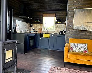 Gezellige woonkamer en keuken in Vakantiehuis in Heijen, Noord Limburg met houtkachel en moderne voorzieningen.