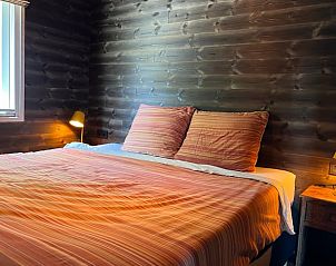 Comfortabele slaapkamer in Vakantiehuis in Heijen, Noord Limburg met warme houten muren en zacht beddengoed.