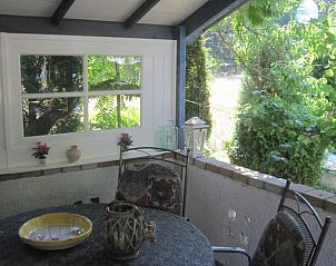 Rustige veranda van Vakantiehuis in Baarlo, Limburg, omgeven door groen.