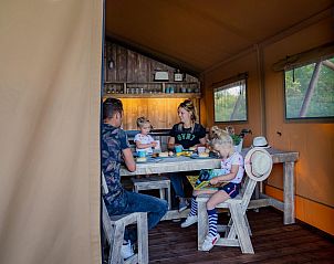 Cozy indoor area of Waterlodge in Maasbree, North Limburg, perfect for 8 people, with an inviting dining table in a glamping lodge.