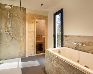 Relax in the luxurious bathroom of Bos Cottage with Sauna and Bubble Bath in Maasbree, North Limburg. Enjoy peace and nature in this vacation home.