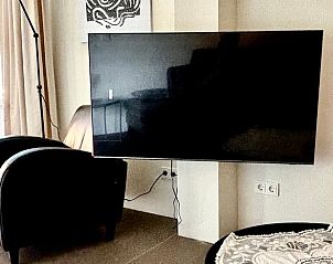 Moderne tv-hoek in Vakantiehuis in Beesel, Noord Limburg, met comfortabele stoelen.