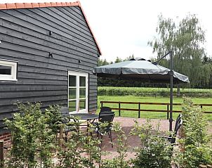 Terras van Vakantiehuis in Baexem, Noord Limburg met uitzicht op groene velden.