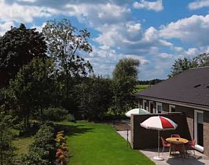 Uitzicht op de tuin van Vakantiehuisje in Bergen, Noord Limburg, omgeven door natuur.