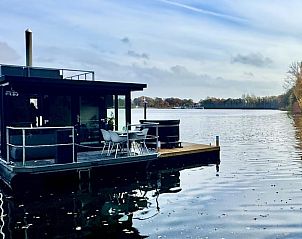 Vakantiehuisje in Middelaar, Noord Limburg, drijvend vakantiehuis met terras aan het water, omgeven door natuur en rust.