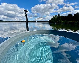 Ontspan in de jacuzzi van Vakantiehuisje in Middelaar, Noord Limburg, met prachtig uitzicht op het meer en de omliggende natuur.
