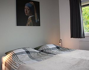 Slaapkamer in Vakantiehuisje in Heijenrath, Zuid Limburg, met tweepersoonsbed en kunst aan de muur.